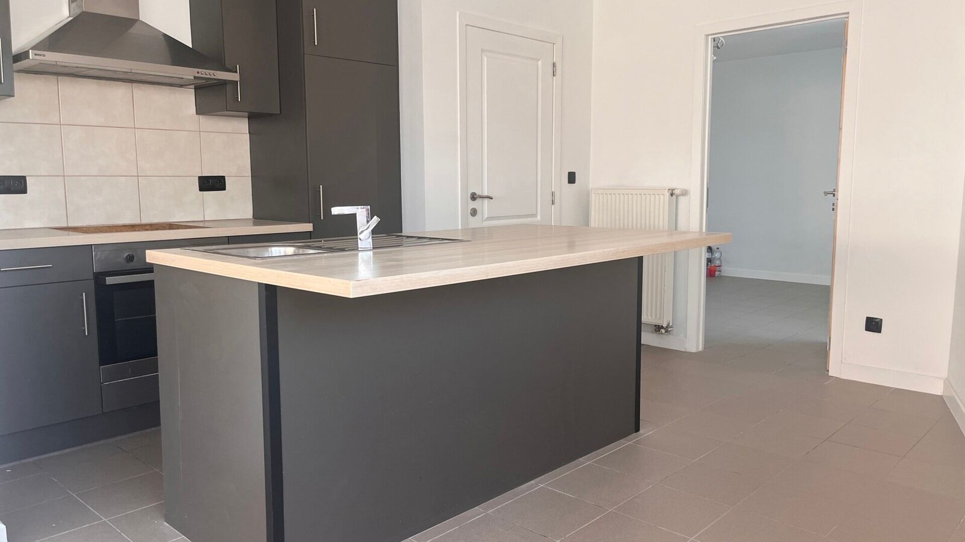 Dit tof duplex-appartement is gelegen in een hoekwoning en omvat de eerste en tweede verdieping. Het eerste verdiep heeft een inkomhal met apart toilet, zeer lichtrijke leefruimte met open geïnstalleerde keuken en aansluitend een berging met aansluiting 