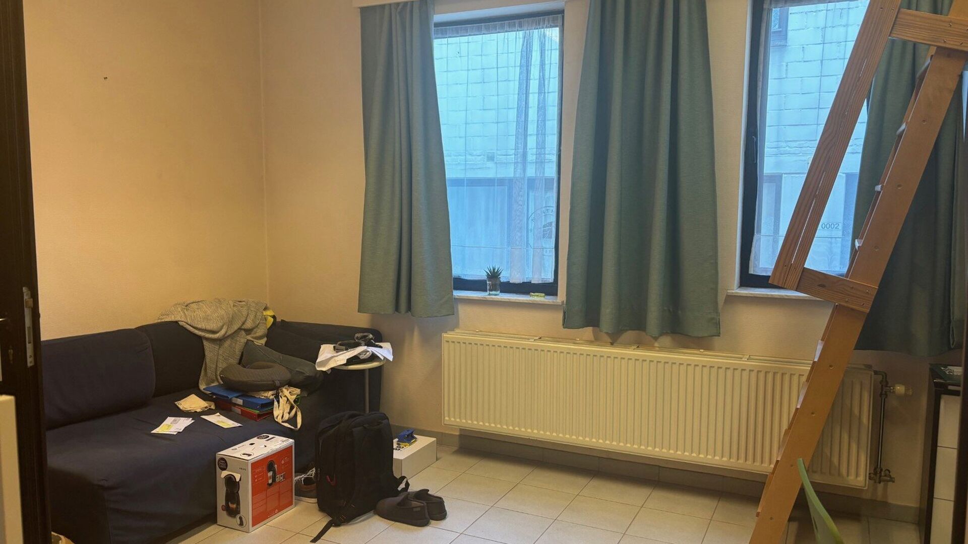 Deze studentenwoning huisvest een aantal kamers en studio's.  De brede inkomgang laat het toe om een fiets binnen te stallen, op de eerste tussenverdieping achteraan bevindt zich een gemeenschappelijke keuken. De kamer zelf bevindt zich op de eerste verdi